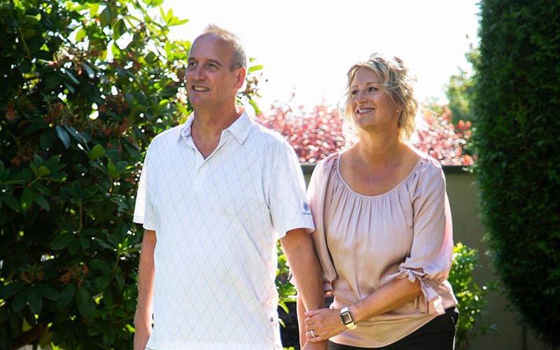 couple walking in sunny yard