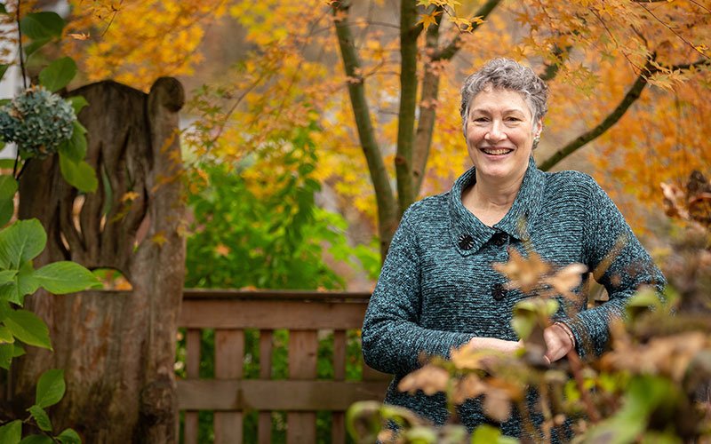 smiling woman among autumn trees