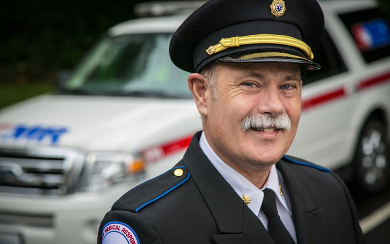 smiling man in front of ambulance